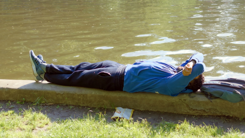 Person lying down with their arms behind their head, appearing to rest